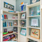 A shelf filled with board games, books, and colorful artwork in a cozy corner of a vacation rental in St. Augustine.