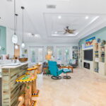 Open-concept living area with a view of the kitchen, custom bar stools, and a comfortable seating area in a vacation rental.