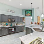 A modern kitchen with gray cabinets, marble countertops, and a well-organized space, perfect for preparing gourmet meals.