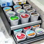 Close-up of various coffee pods neatly organized in a drawer, offering a variety of flavors for guests at a St. Augustine vacation rental.